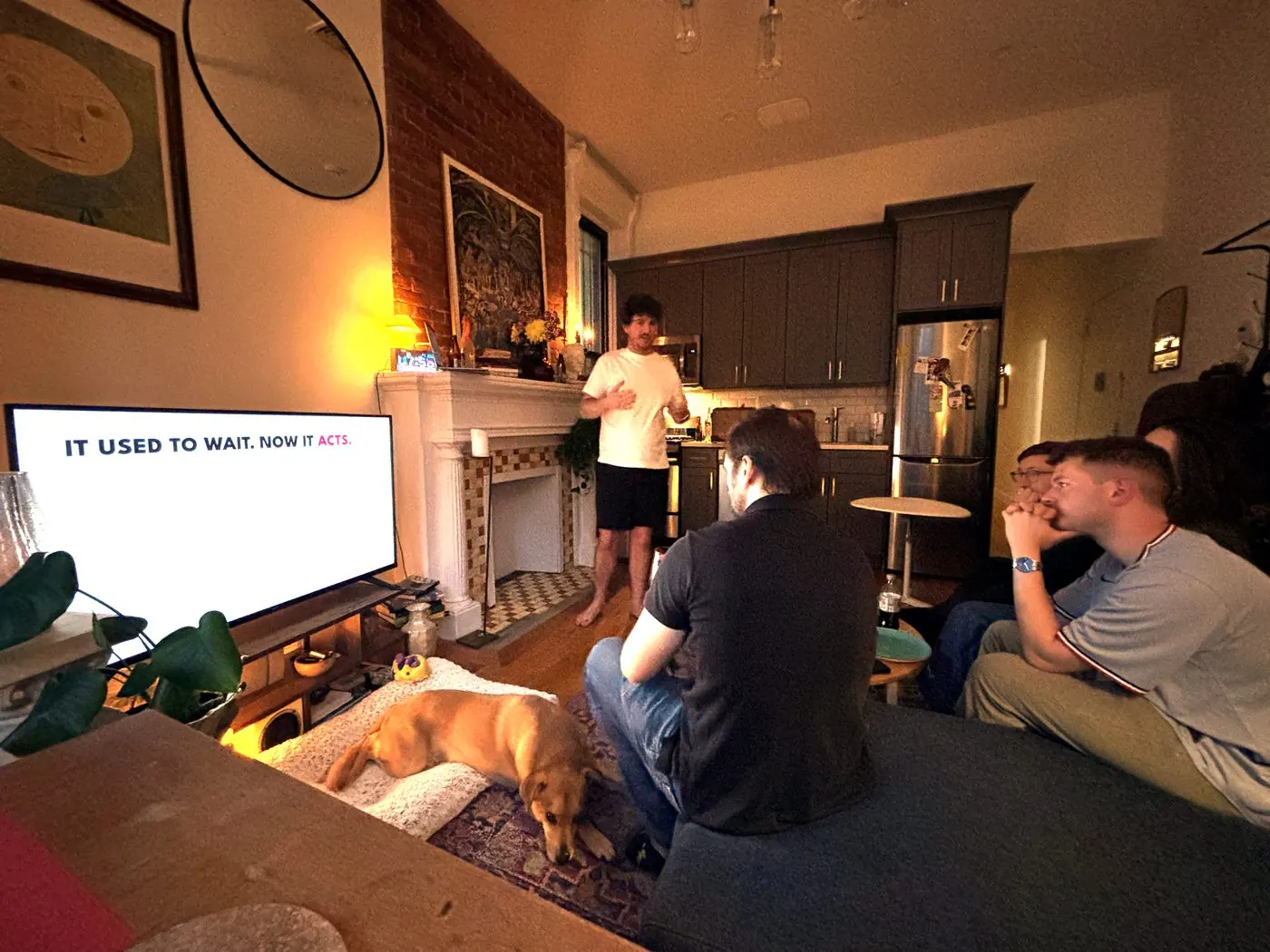 Neighbors on a couch watching an AI Reality Check presentation on a living-room TV, a dog asleep on the rug