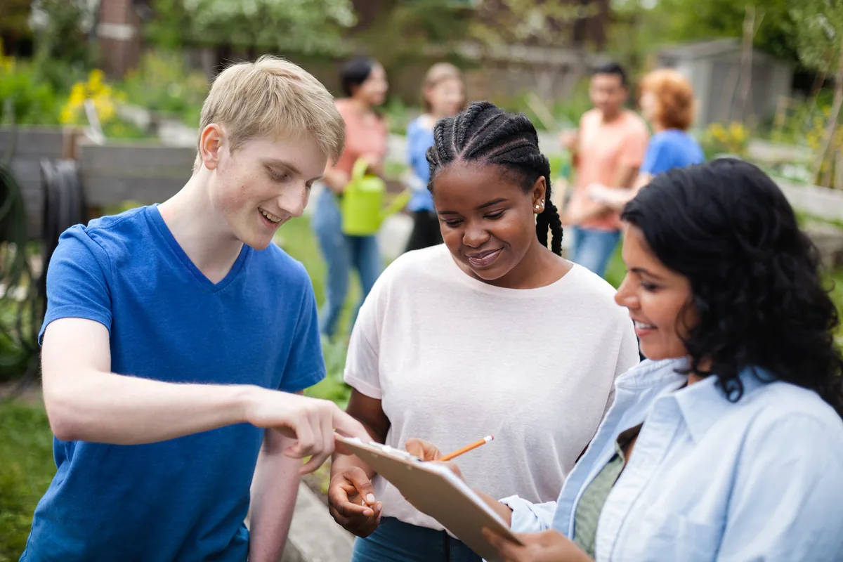 Young volunteers plan a community project together outdoors