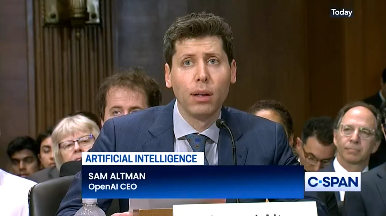 Sam Altman, OpenAI CEO, testifying to the US Senate in 2023. C-SPAN lower-third identifies him during the Artificial Intelligence hearing. Editorial quote: 'Regulation of AI is essential.'